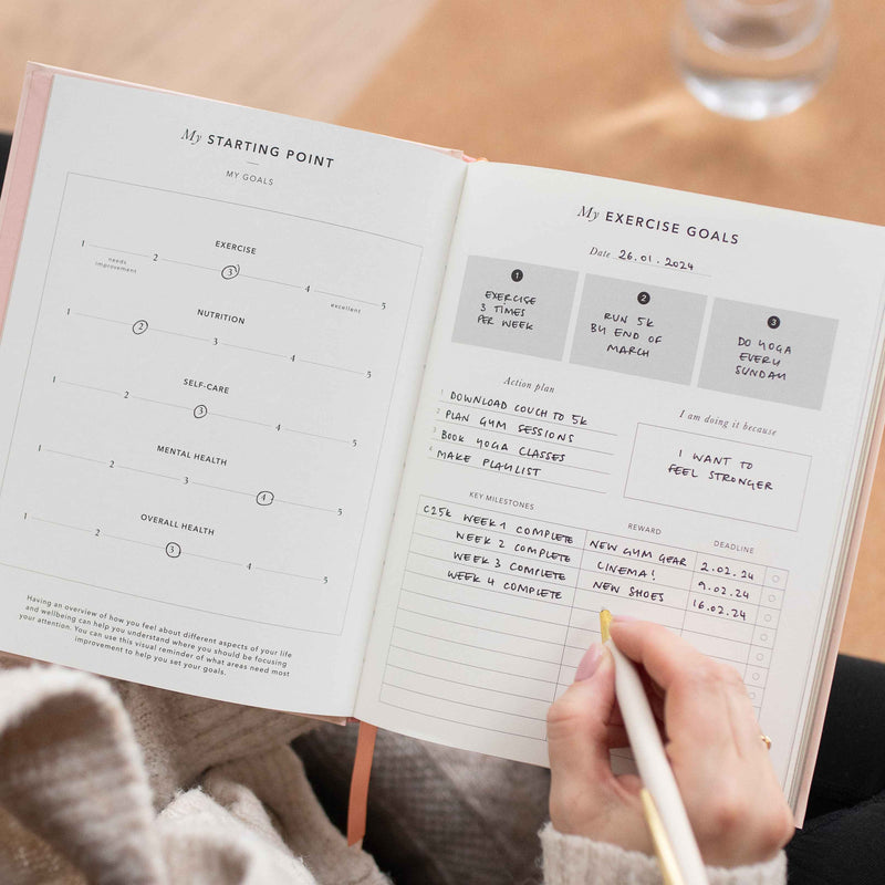 Person holding a planner with exercise goals 